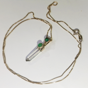 Cadena de oro con colgante de cuarzo translúcido y esmeraldas incrustadas